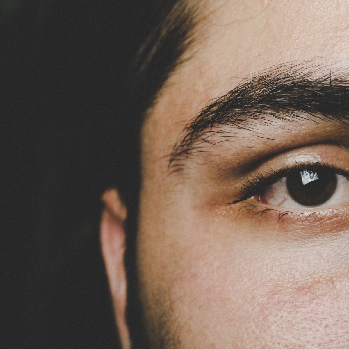 Close-up of eyebrows on a calm adult face, where seborrheic dermatitis often causes flaking