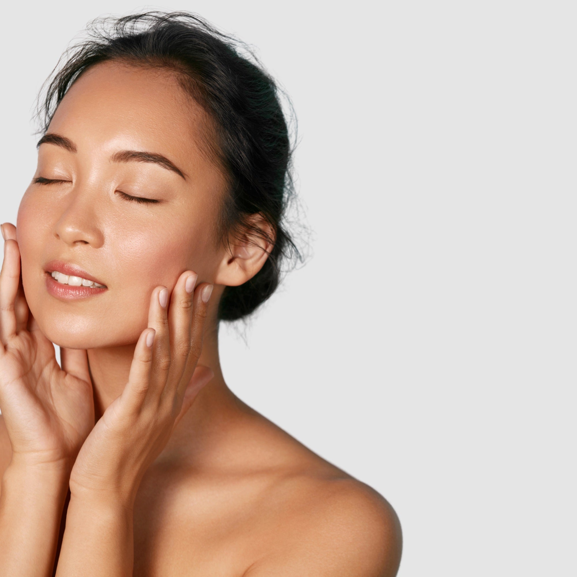 Woman touching her face with a neutral background