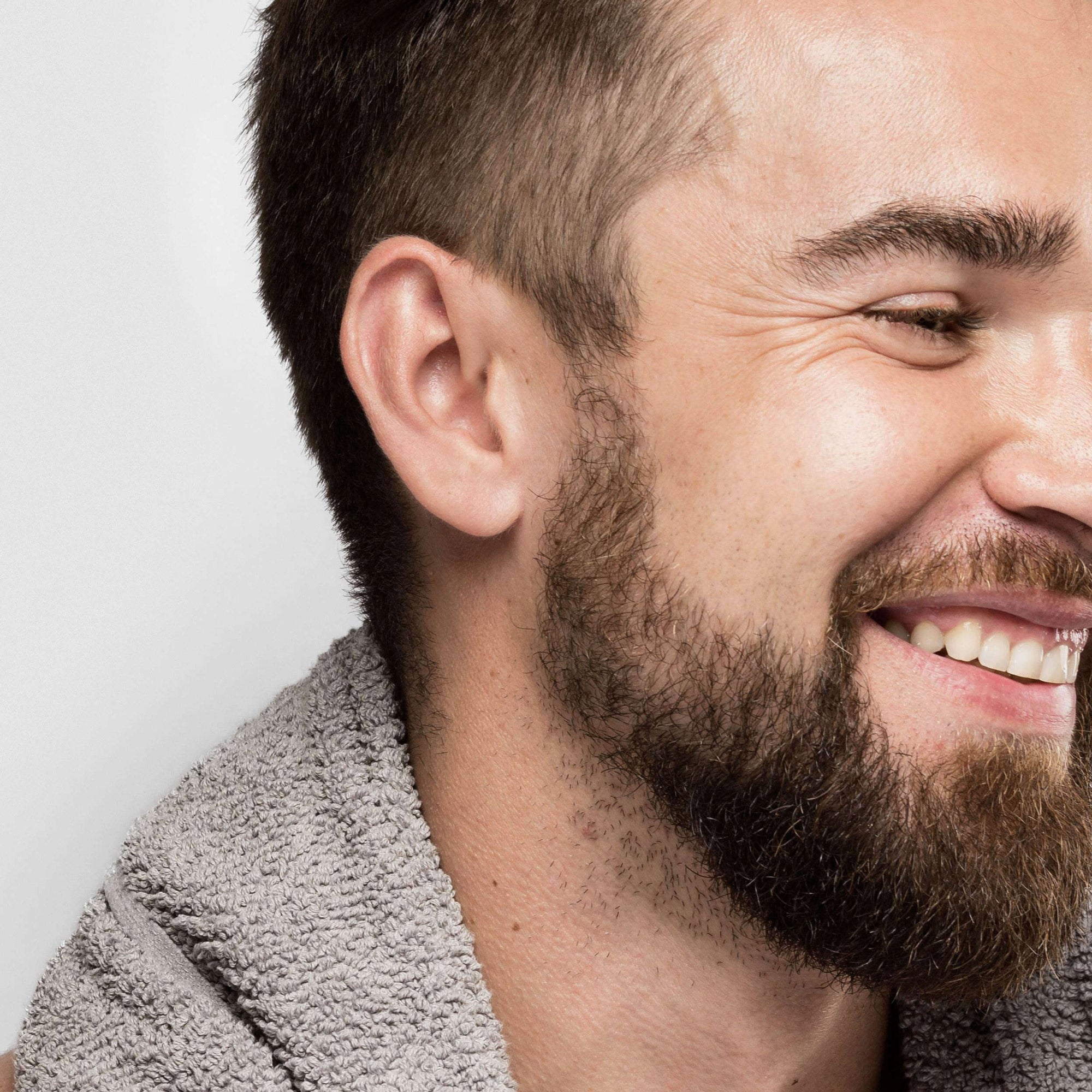 Bearded man smiling with towel around the neck