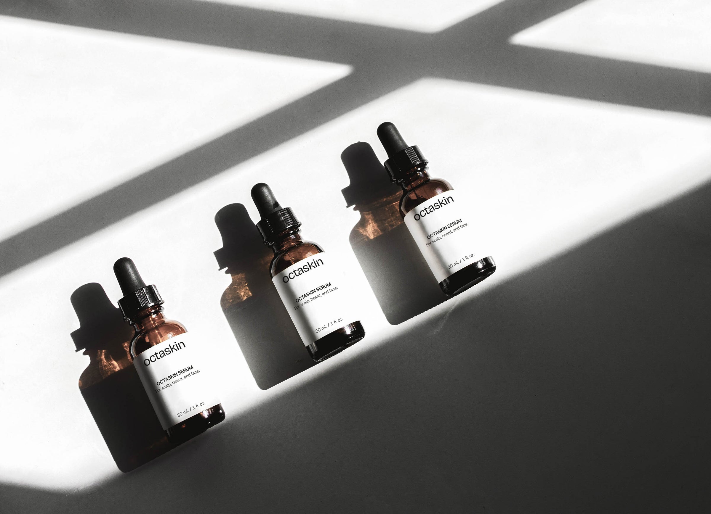 Three Octaskin Serum dropper bottles with labels on a light background