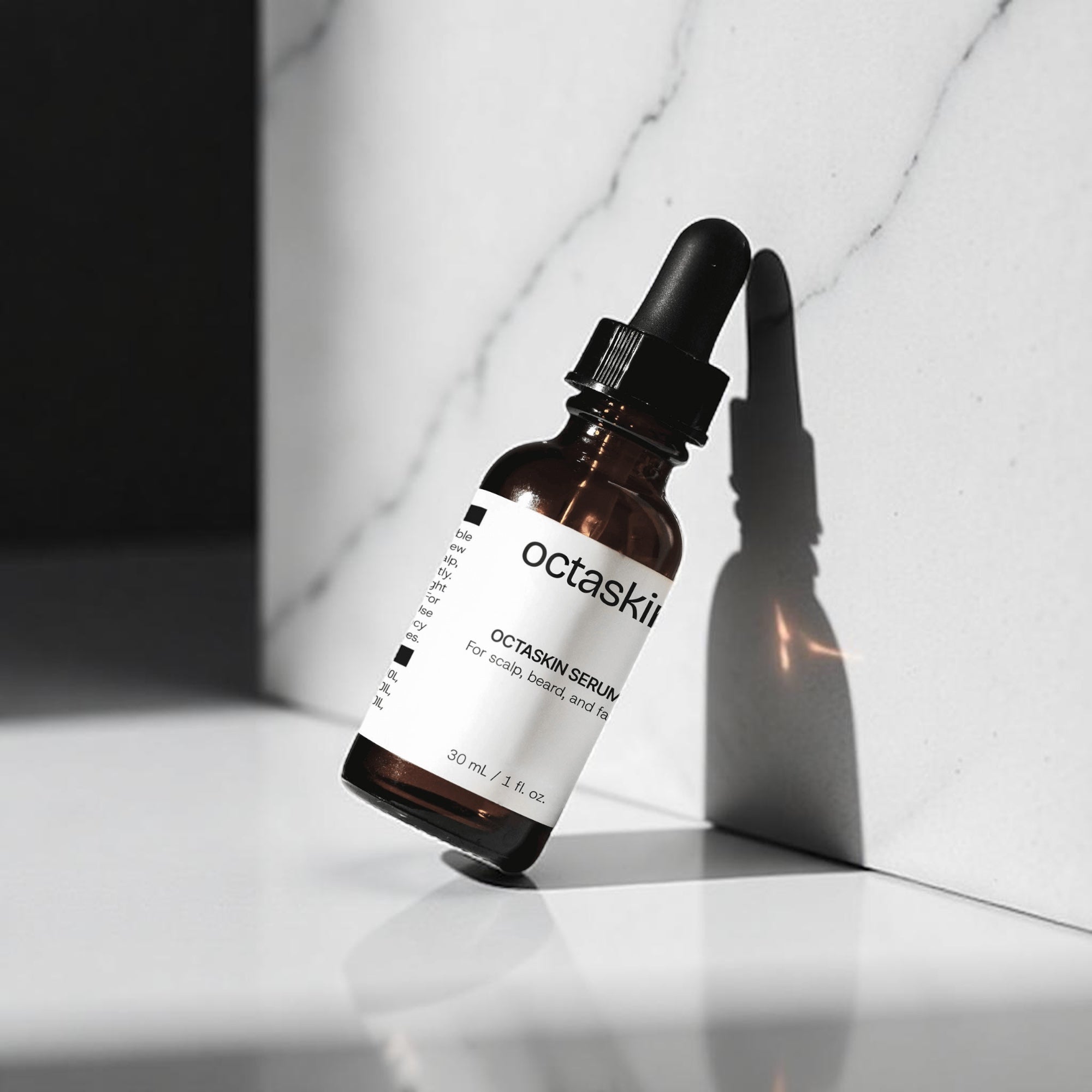 Octaskin Serum glass bottle with dropper labeled 'octaskin' on a white surface.
